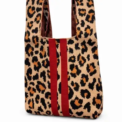Mala de tecido com padrão animal print castanho e riscas vermelhas.