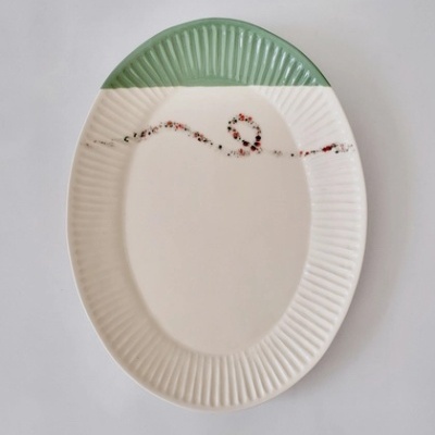 Prato oval branco com secção verde e padrão ondulado colorido