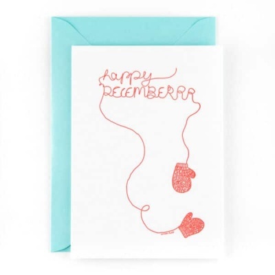 Cartão branco com desenho vermelho de luvas e texto 'happy DECEMBER' com envelope azul