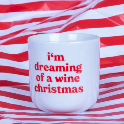 Caneca branca com texto vermelho sobre fundo de riscas vermelhas e brancas