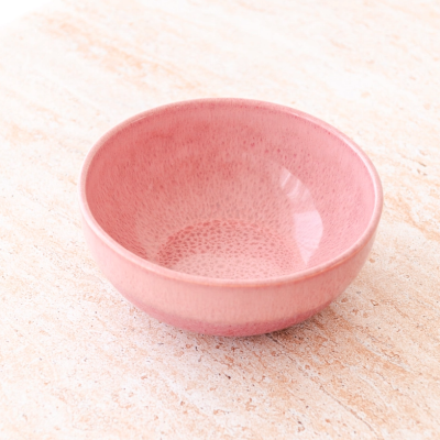 Taça de cerâmica rosa texturizada numa superfície clara