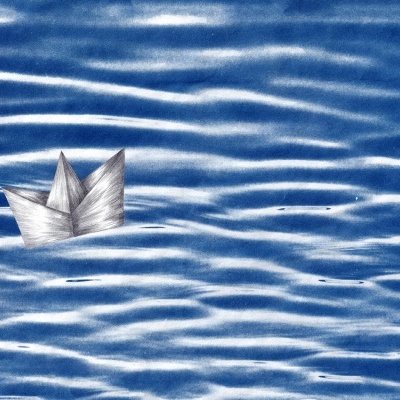 Barco de papel de origami cinzento sobre superfície azul com ondas brancas.