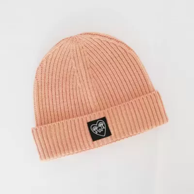 Gorro de malha cor de salmão com etiqueta preta e coração branco na dobra