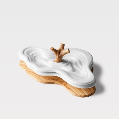 Tabuleiro decorativo com base de madeira clara e tampa branca ondulada com puxador em forma de ramo