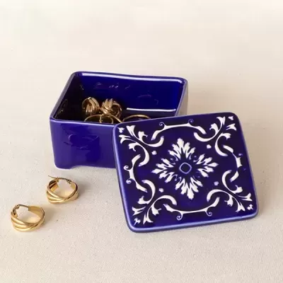 caixa decorativa azul com tampa branca e brincos dourados
