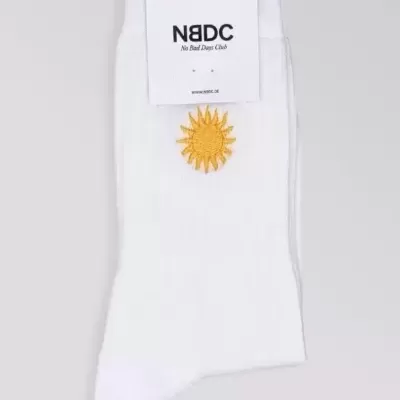 Meias brancas com sol amarelo bordado e etiqueta NBDC