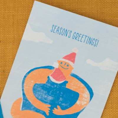 Cartão de boas festas com figura sorridente e chapéu de Natal