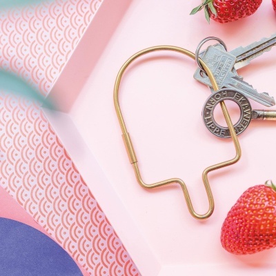 porta-chaves dourado em forma de pirulito com chaves e morangos