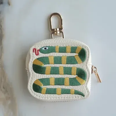 Bolsa pequena branca com bordado de cobra verde e amarelo e fecho dourado