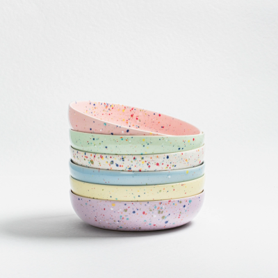 Cinco tigelas coloridas empilhadas com padrão de respingos coloridos