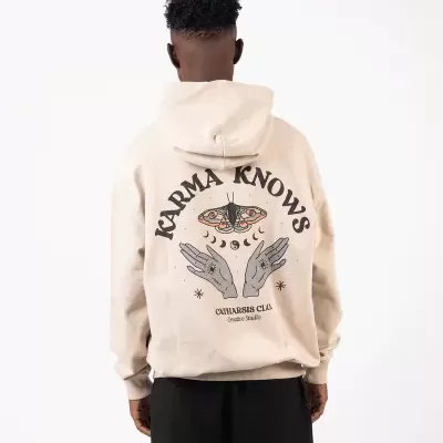 Casaco com capuz bege com estampa artística nas costas e texto, usado por modelo em fundo branco.