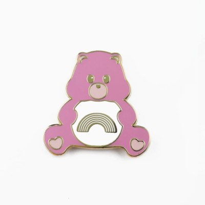 Pino metálico urso cor-de-rosa com arco-íris dourado no centro, fundo branco