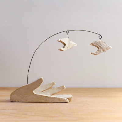 Escultura decorativa mão com peixes pendurados