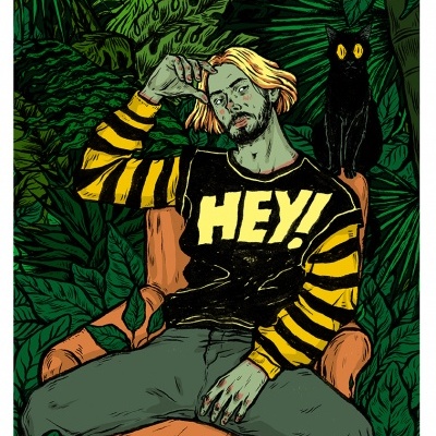 Homem loiro com camisola preta e amarela 'HEY!' sentado em poltrona laranja com gato preto e folhagem verde ao fundo