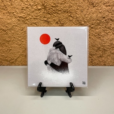 Azulejo decorativo com ilustração de duas pessoas a abraçar, aves pretas e círculo vermelho.