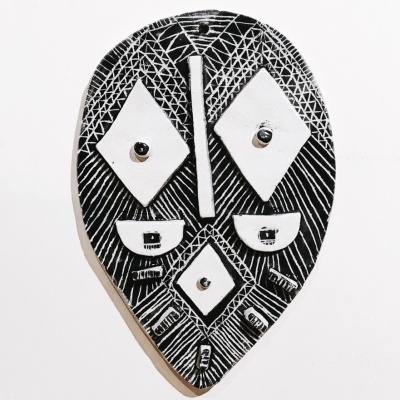 Máscara decorativa preta e branca com padrão geométrico e elementos faciais abstratos
