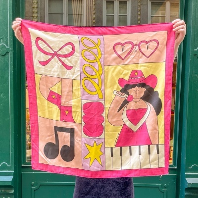 Pano quadrado decorativo com ilustrações coloridas incluindo mulher a cantar e símbolos musicais.