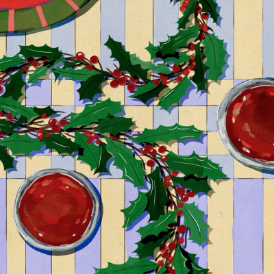 Toalha de mesa às riscas com azevinhos, copos com bebida vermelha e prato vermelho.