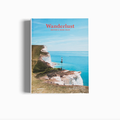 Livro Wanderlust com capa azul e imagem de farol na costa