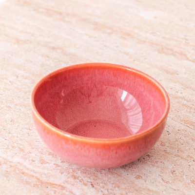 Taça pequena rosa e laranja em cerâmica sobre superfície clara