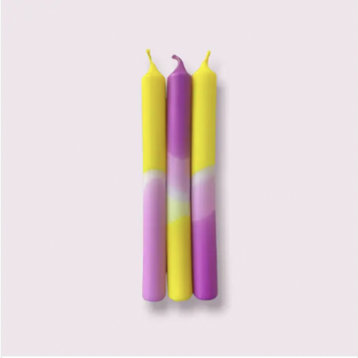 Conjunto de três velas coloridas em amarelo, roxo e rosa