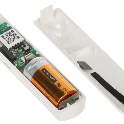 Peça eletrônica branca aberta com pilha AA laranja e placa com código QR