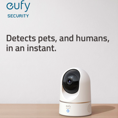 Câmara de segurança Eufy branca com lente preta sobre superfície de madeira