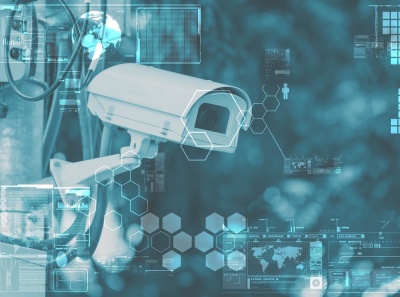 Câmara de segurança branca montada numa parede com gráficos tecnológicos em azul