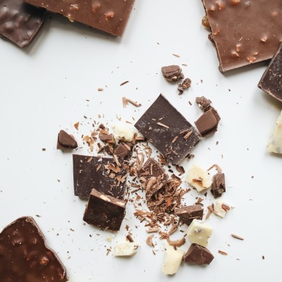 Barras de chocolate de vários tipos espalhadas sobre uma superfície branca