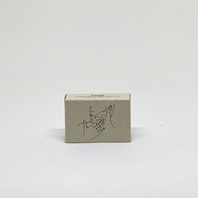 Caixa pequena de cartão com ilustração minimalista de rosto e mão