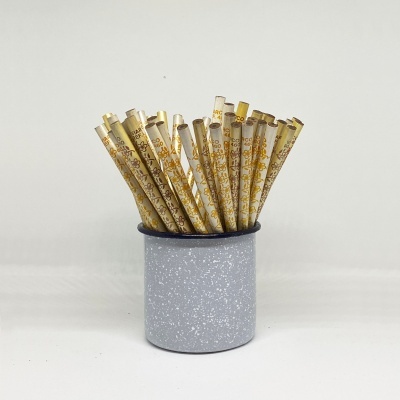 Palhinhas descartáveis bege com padrão dourado num recipiente cinzento