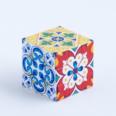 Cubo mágico com padrão de azulejo colorido em azul, amarelo, vermelho e verde.