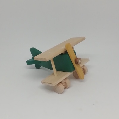 Avião de brincar em madeira verde e amarelo sobre fundo branco