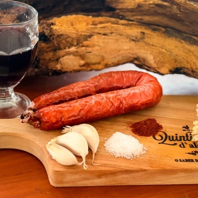 Tábuas de madeira com chouriço, alho, sal, especiarias e copo de vinho tinto