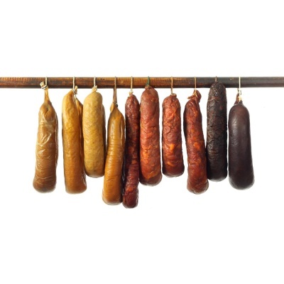 Oito enchidos pendurados numa vara de madeira, em vários tons de castanho e vermelho