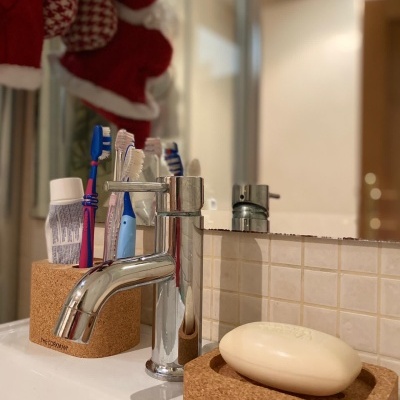 Suporte de cortiça para escovas de dentes e sabonete numa pia de casa de banho