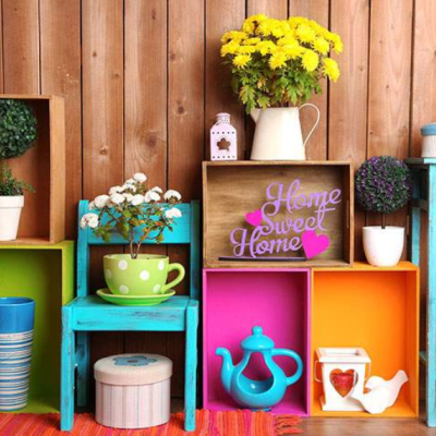 Decoração com caixas coloridas, vasos com plantas, placa 'Home Sweet Home' e móvel azul de madeira