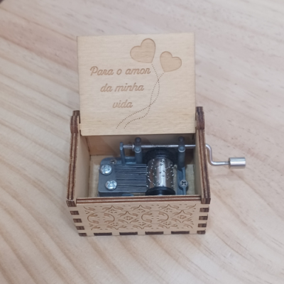 Caixa musical de madeira com tampa gravada e manivela lateral