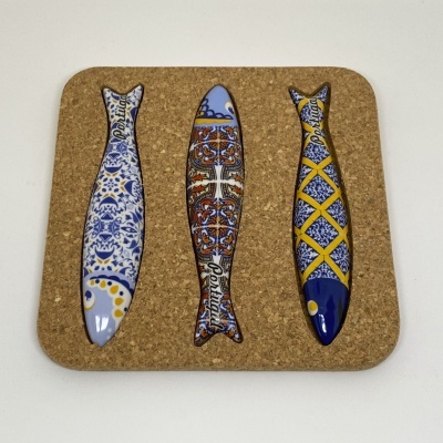 Conjunto de três peixes decorativos em cerâmica sobre base de cortiça