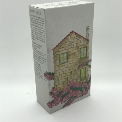 Caixa de embalagem com desenho de casa de pedra e flores em fundo branco