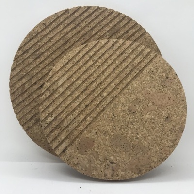 Dois suportes redondos de cortiça com riscas diagonais em fundo branco