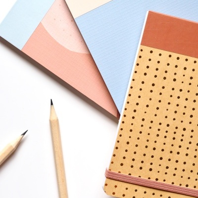 Cadernos coloridos e lápis de madeira sobre fundo branco