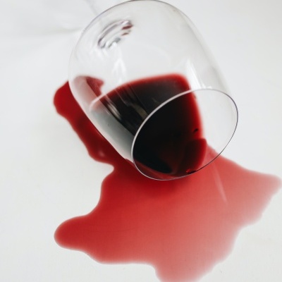 Copo de vidro virado com vinho tinto derramado