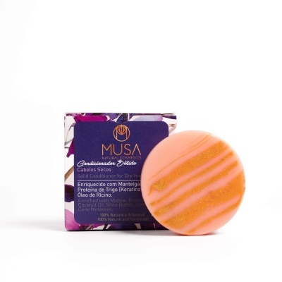 Condicionador sólido laranja com embalagem roxa da marca MUSA para cabelos secos