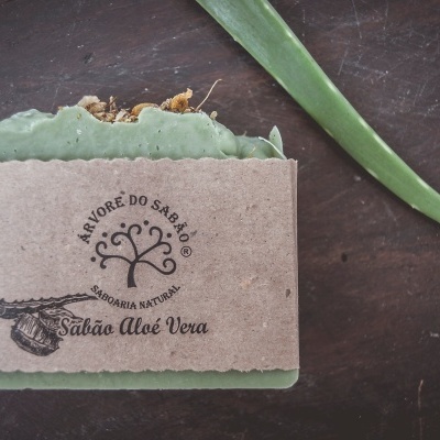 Sabonete verde com etiqueta em papel reciclado e folha de aloé vera ao lado