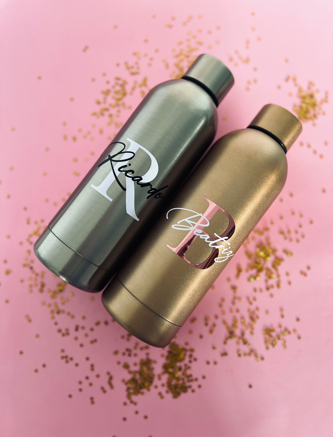 Garrafa Térmica Garrafas metálicas personalizadas com nomes Ricardo e Betty em fundo rosa com confetes dourados