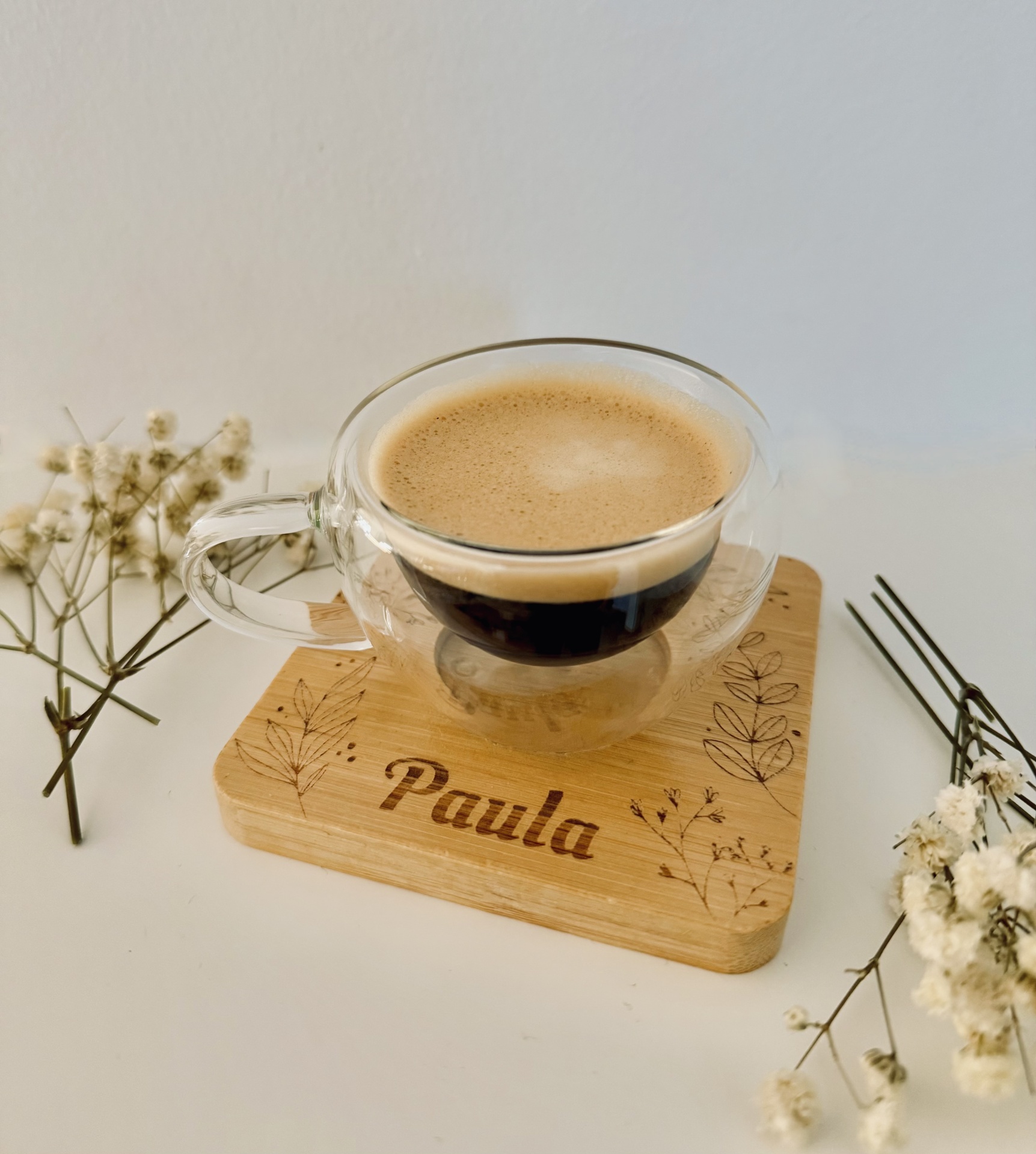 Chávena de Café chávena de vidro com café espresso sobre base de madeira gravada com o nome Paula