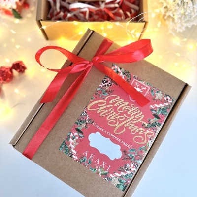 Caixa de presente de cartão com etiqueta 'Merry Christmas' e laço vermelho