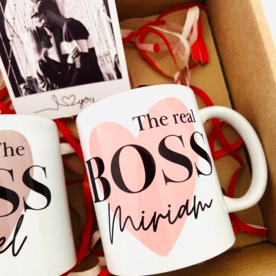 Duas canecas brancas dentro de caixa de cartão com fitas vermelhas e cartão fotográfico