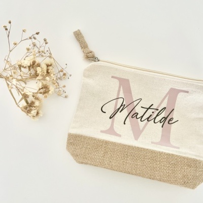 Necessaire bege com inicial M e nome Matilde ao lado de flores secas